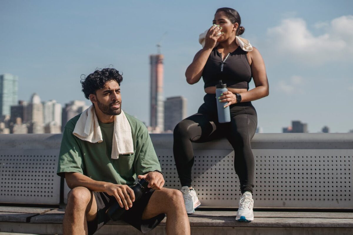 Two people resting after exercise in a city setting, promoting a healthy lifestyle.